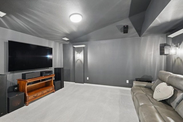 carpeted cinema featuring lofted ceiling and baseboards