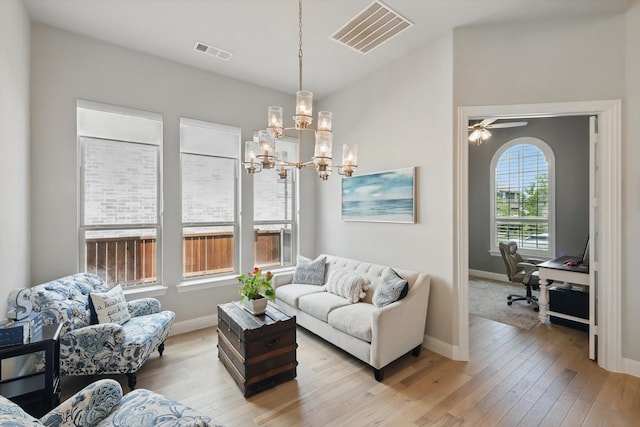 living area with baseboards, visible vents, and light wood-style flooring