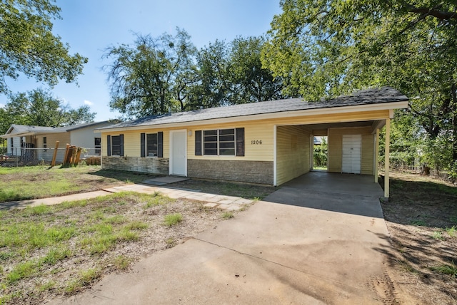 1206 E SE 2nd Ave, Mineral Wells, TX 76067 - view of front of home featuring driveway, fence, an attached carport, and stone siding
