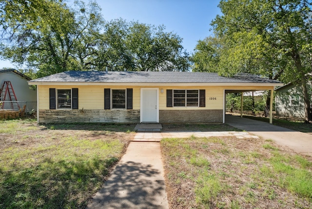 1206 E SE 2nd Ave, Mineral Wells, TX 76067 - ranch-style house with concrete driveway, a carport, stone siding, and fence
