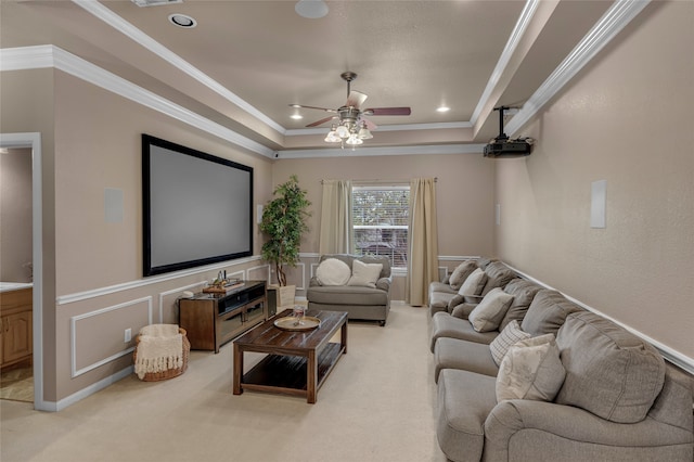 cinema featuring light colored carpet, a wainscoted wall, ceiling fan, crown molding, and a tray ceiling