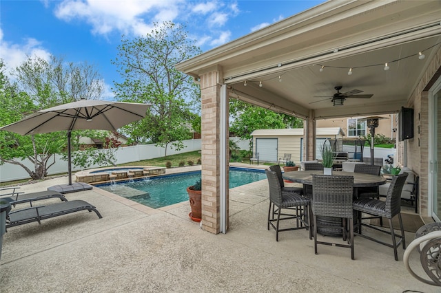 view of swimming pool with a patio area, an outbuilding, outdoor dining area, ceiling fan, and a fenced backyard