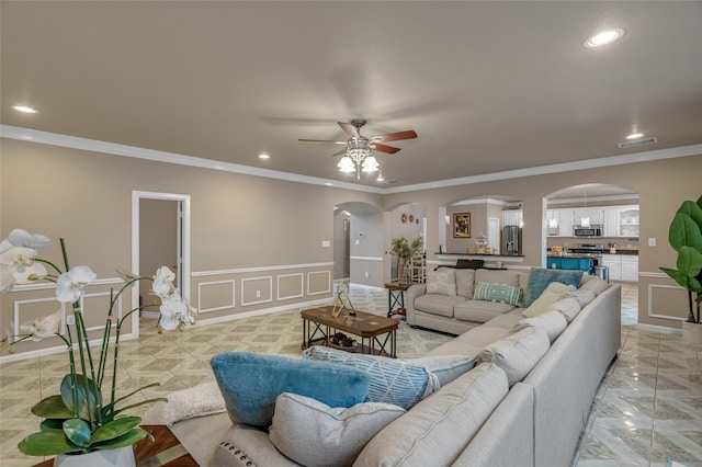 living area with visible vents, ceiling fan, arched walkways, recessed lighting, and a decorative wall