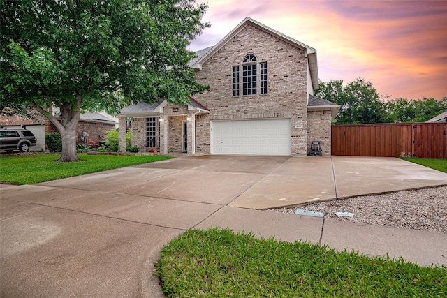 view of front of property featuring a gate, brick siding, fence, concrete driveway, and an attached garage