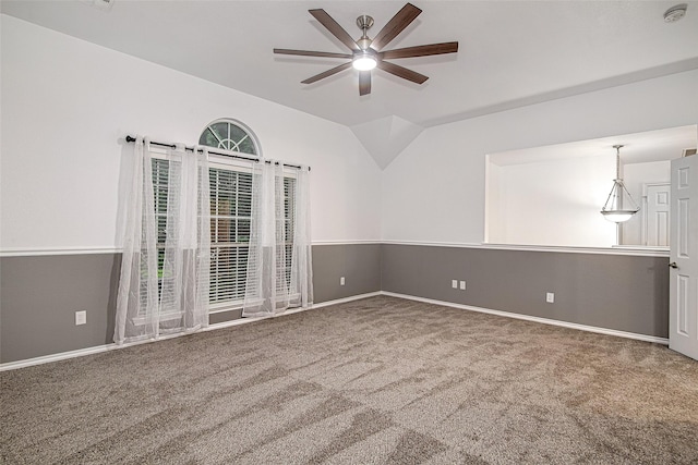 carpeted spare room featuring baseboards, ceiling fan, and vaulted ceiling
