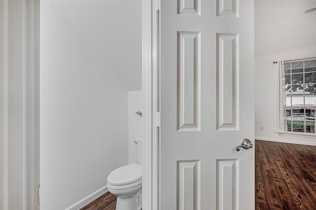 bathroom with wood finished floors, toilet, and baseboards