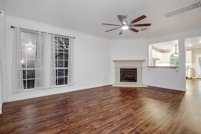 unfurnished living room with crown molding, a ceiling fan, visible vents, and wood finished floors