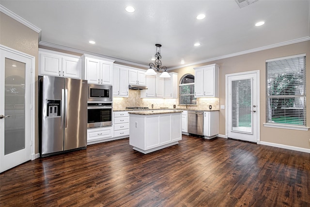 kitchen with white cabinetry, stainless steel appliances, decorative backsplash, and ornamental molding