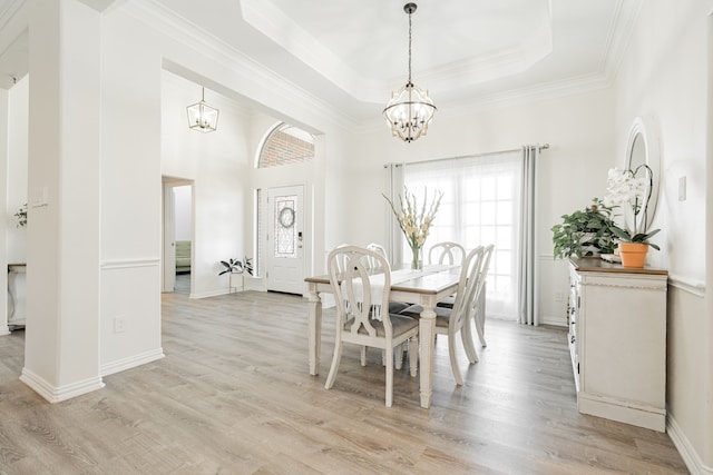 dining space with an inviting chandelier, crown molding, and light wood-style flooring