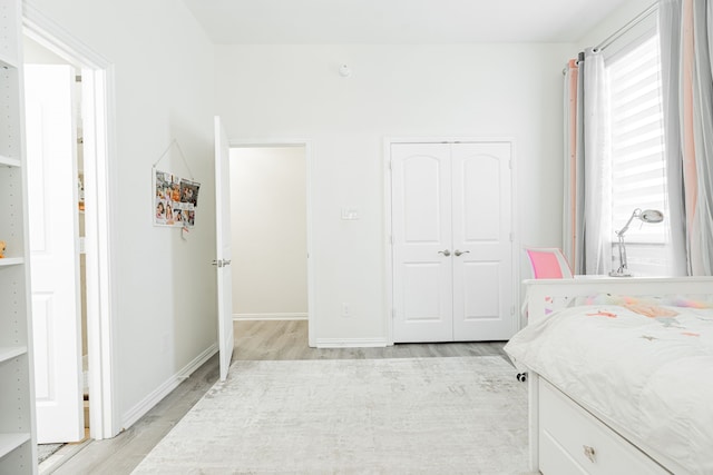 bedroom featuring a closet, baseboards, and light wood-style floors