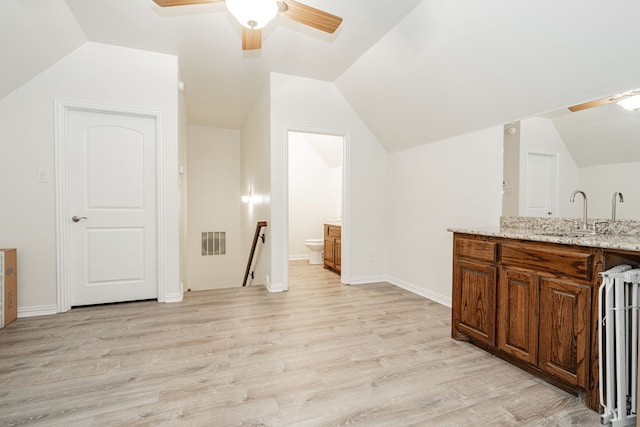 additional living space with lofted ceiling, visible vents, a ceiling fan, and radiator
