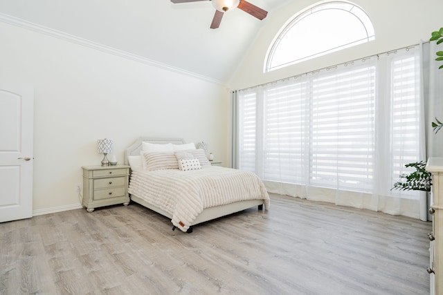 bedroom with light wood-type flooring, a ceiling fan, high vaulted ceiling, and baseboards