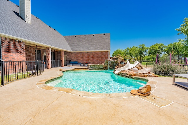 view of pool featuring fence, a patio area, a water slide, and a fenced in pool