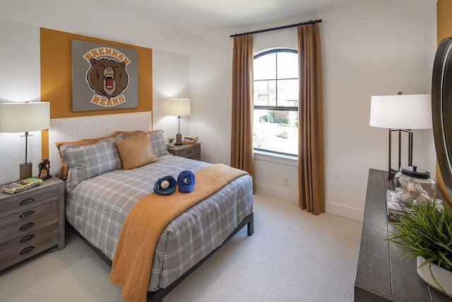 bedroom with baseboards and light carpet