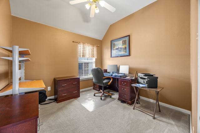 office space featuring baseboards, ceiling fan, light carpet, and vaulted ceiling