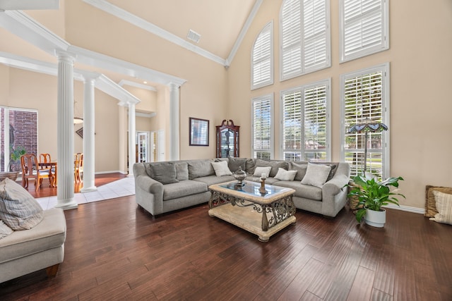 living room featuring ornate columns, high vaulted ceiling, visible vents, and baseboards