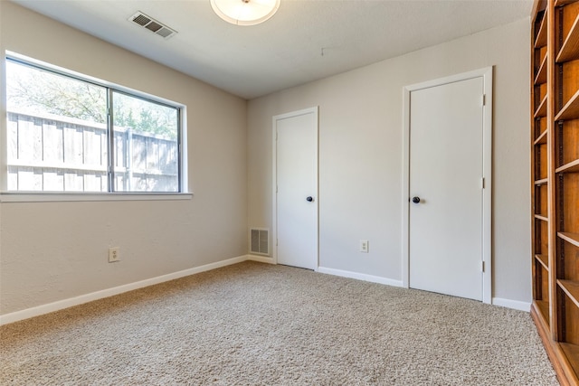 unfurnished bedroom featuring visible vents, carpet flooring, and baseboards