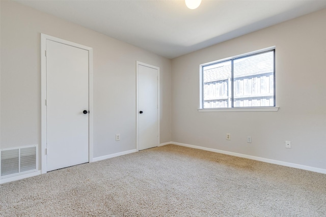 unfurnished bedroom with baseboards, visible vents, and carpet floors