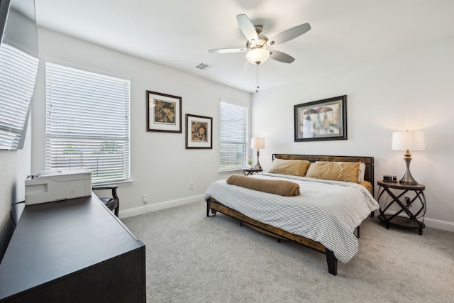 bedroom featuring visible vents, baseboards, a ceiling fan, and light carpet