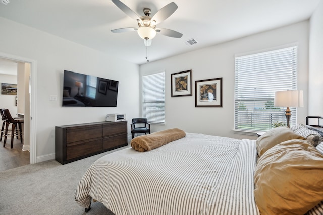 bedroom featuring visible vents, a ceiling fan, baseboards, and light carpet