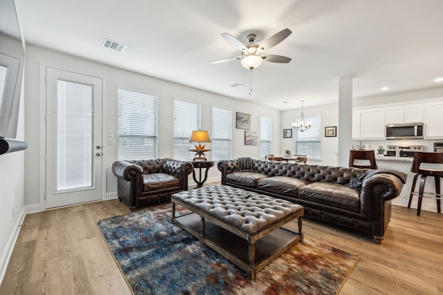 living room with visible vents, baseboards, light wood-type flooring, recessed lighting, and ceiling fan with notable chandelier