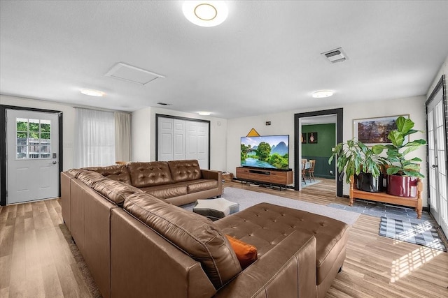 living area featuring attic access, visible vents, and light wood-type flooring