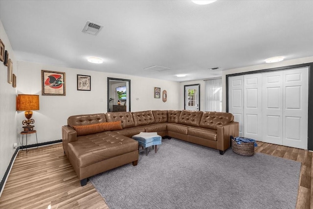living area featuring visible vents, wood finished floors, and baseboards