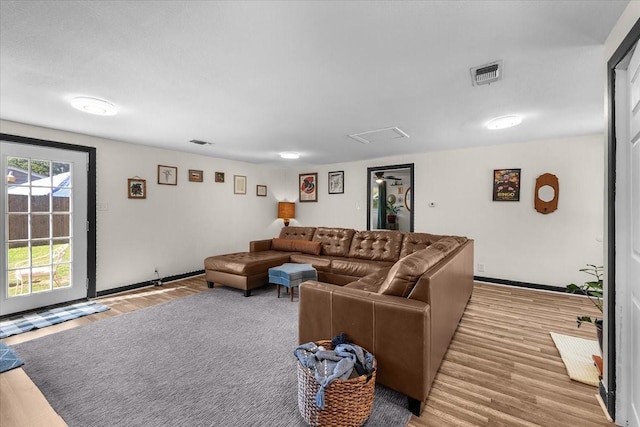 living room with wood finished floors, visible vents, and baseboards