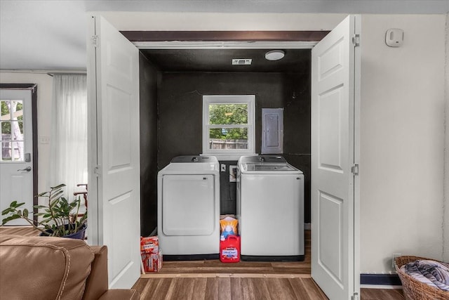 laundry room featuring wood finished floors, laundry area, and washing machine and dryer