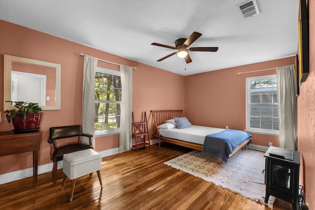 bedroom with hardwood / wood-style floors, multiple windows, and baseboards