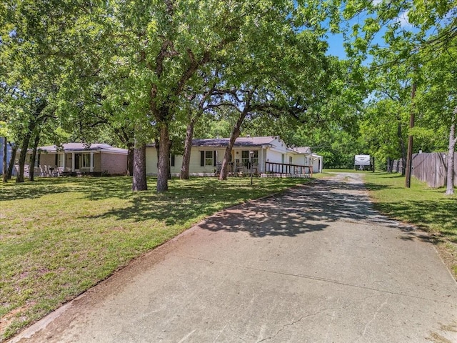 view of front of home featuring fence, driveway, and a front yard