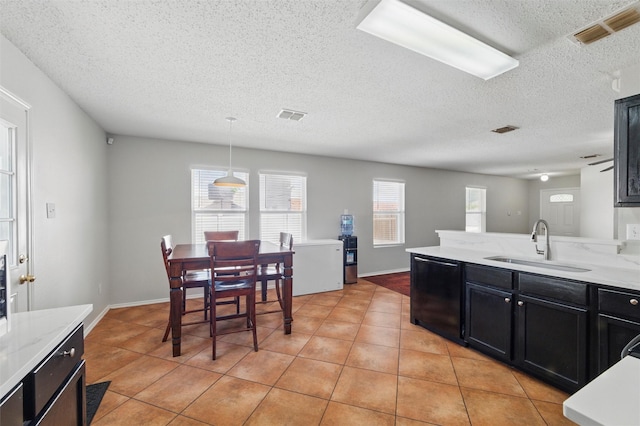 kitchen featuring visible vents, a textured ceiling, dishwasher, and a sink