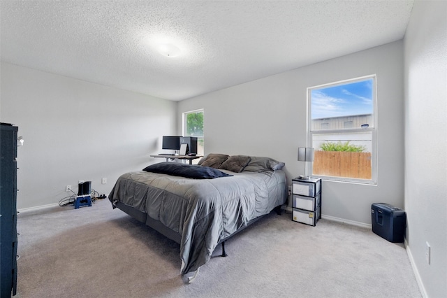bedroom featuring a textured ceiling, baseboards, and carpet floors