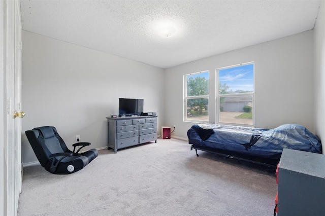 bedroom with baseboards, carpet floors, and a textured ceiling