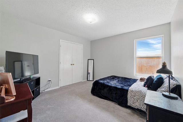 bedroom featuring light carpet and a textured ceiling