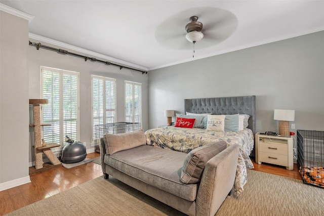 bedroom featuring crown molding, ceiling fan, wood finished floors, and baseboards