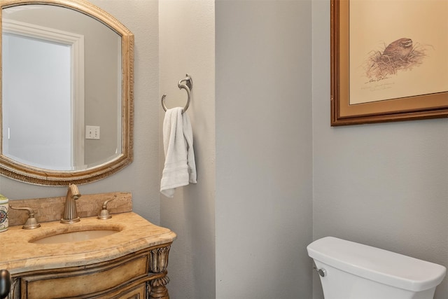 half bathroom with toilet and vanity