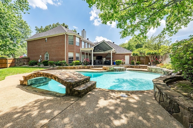 view of pool with a fenced backyard, a pool with connected hot tub, and a patio area