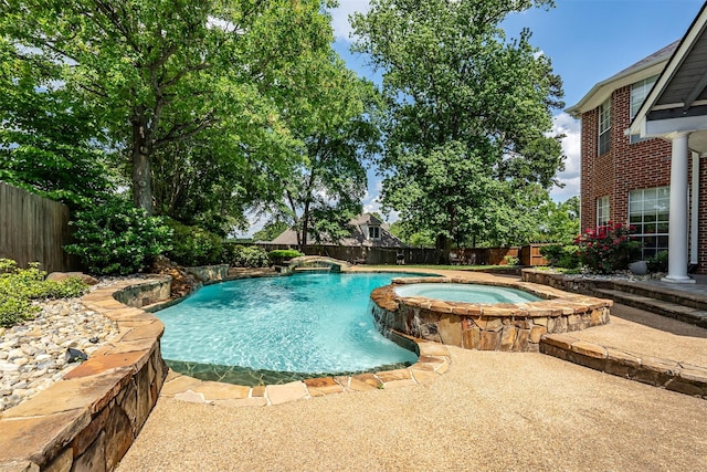 view of pool featuring a patio, a fenced backyard, and a pool with connected hot tub