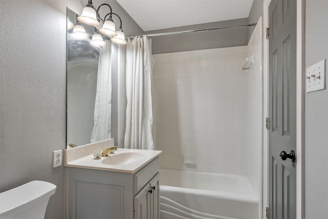 bathroom featuring shower / bath combo with shower curtain, a textured wall, toilet, and vanity