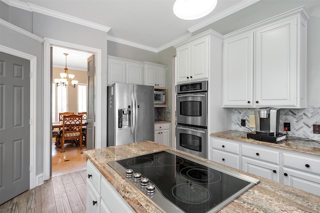 kitchen with a chandelier, light wood-style floors, appliances with stainless steel finishes, and white cabinetry