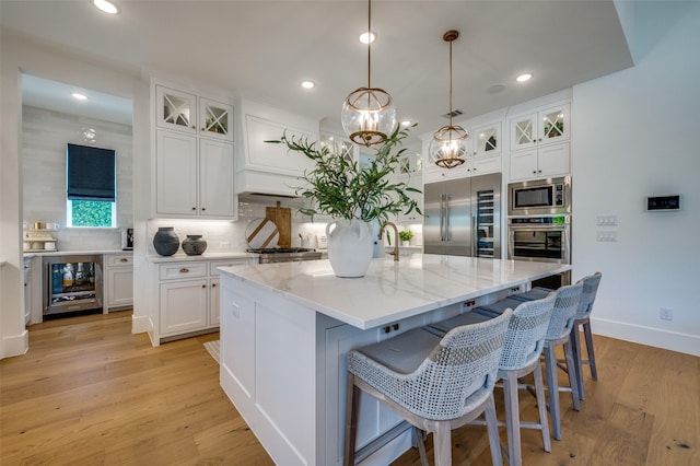 kitchen with built in appliances, beverage cooler, white cabinetry, and decorative backsplash