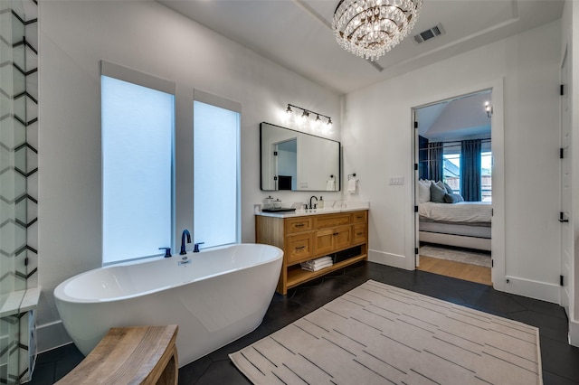bathroom with visible vents, ensuite bathroom, a chandelier, a freestanding tub, and vanity