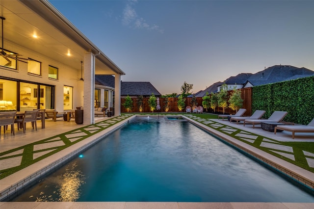 pool at dusk featuring an outdoor hangout area, a fenced backyard, a fenced in pool, and a patio area