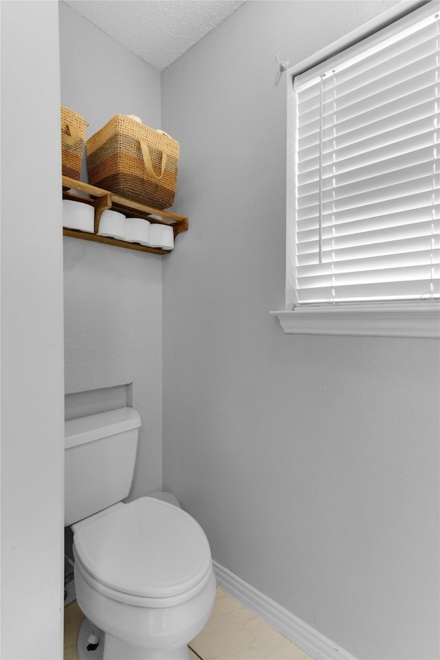 bathroom featuring toilet and baseboards