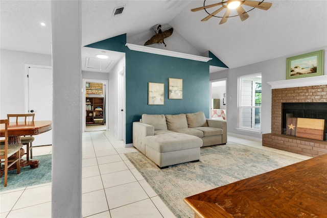 living room with lofted ceiling, light tile patterned flooring, ceiling fan, and attic access