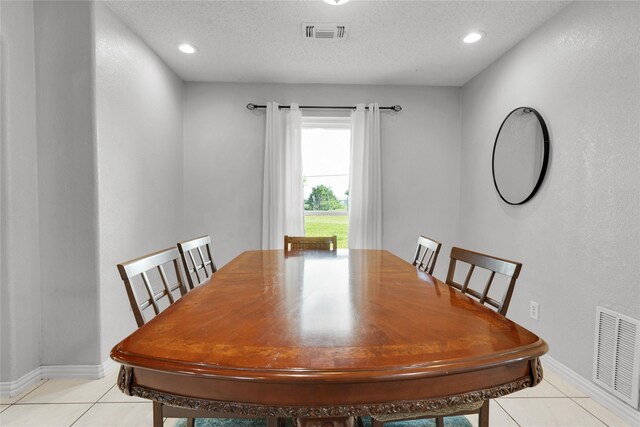 dining space featuring light tile patterned floors, visible vents, and baseboards