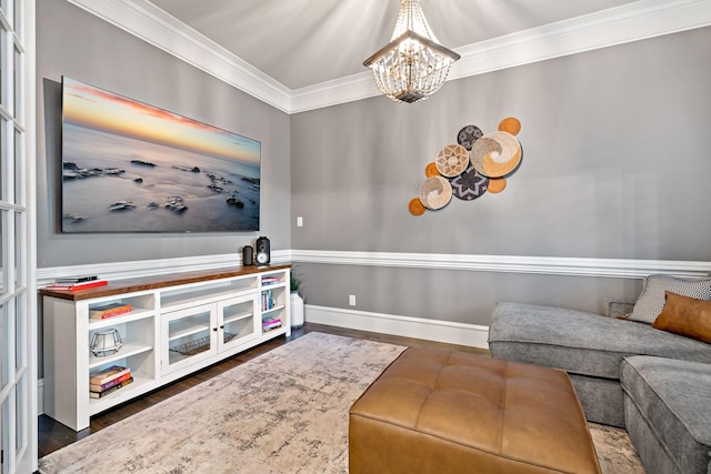 living area with ornamental molding, a notable chandelier, and wood finished floors