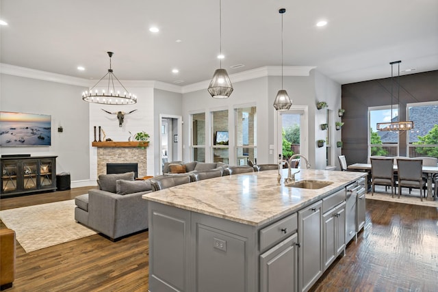 kitchen with gray cabinets, an inviting chandelier, plenty of natural light, and a sink