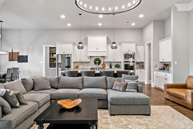 living area featuring an inviting chandelier, dark wood-style flooring, visible vents, and recessed lighting